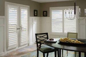 Stylish Hunter Douglas shutters, as a French door window covering idea, in a dining room at Kerrville Window Fashionsnear Kerrville, TX