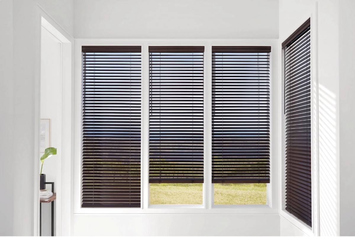 Dark and chic Hunter Douglas wood blinds on four windowpanes in a home’s hallway at Kerrville Window Fashionsnear Kerrville, TX